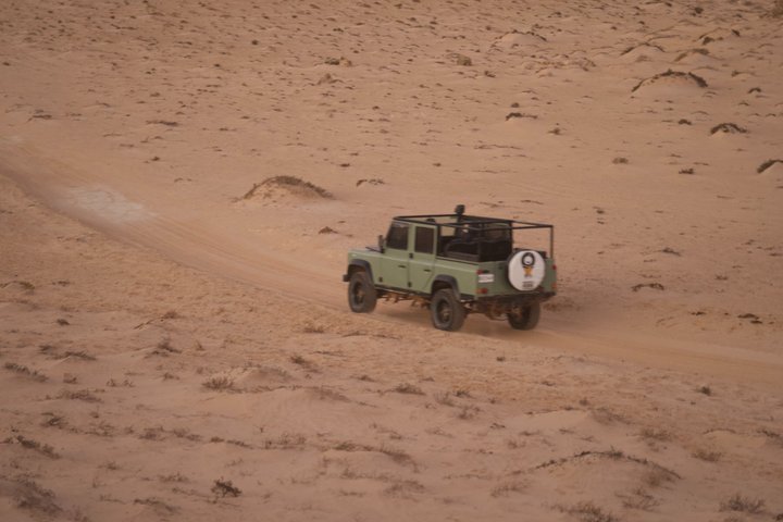 Exploración y sandboarding en las dunas blancas con un Land Rover Safari clásico.