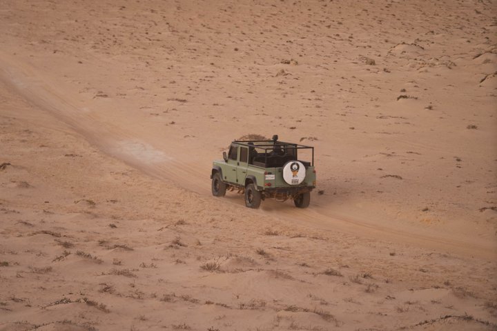 Exploración y sandboarding en las dunas blancas con un Land Rover Safari clásico.
