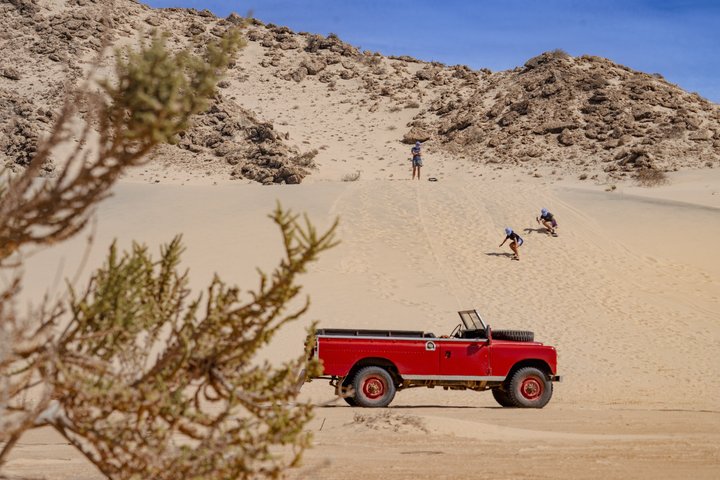 Exploración y sandboarding en las dunas blancas con un Land Rover Safari clásico.