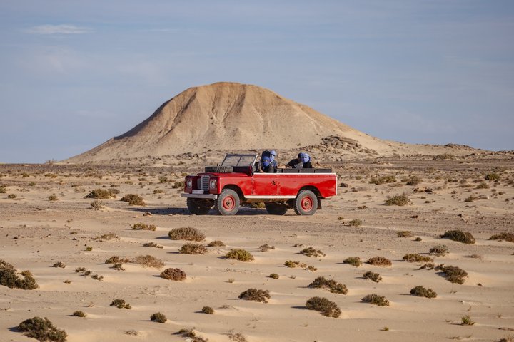 Exploración y sandboarding en las dunas blancas con un Land Rover Safari clásico.