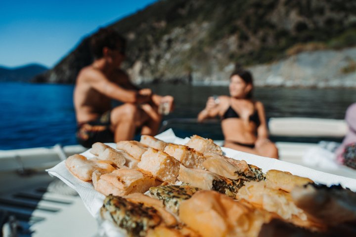 Experiencia de paseo en barco al atardecer en Cinque Terre con aperitivo y baño.