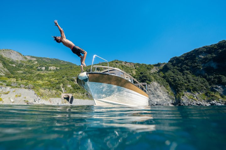 Experiencia de paseo en barco al atardecer en Cinque Terre con aperitivo y baño.